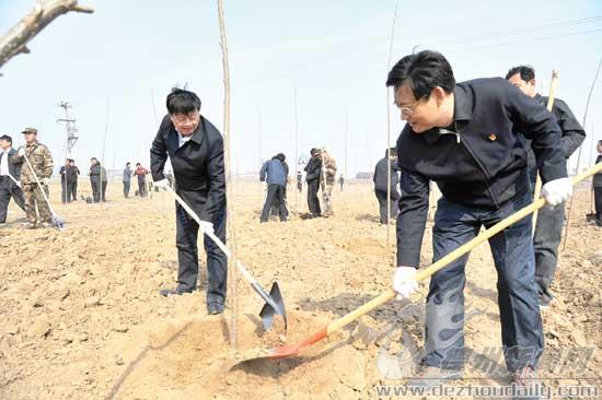 圖為康志民、王春利同黨員志愿者一起參加義務植樹活動。 記者 永翔 攝